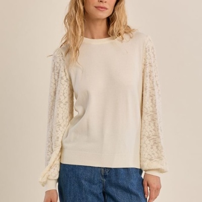 Camisola creme com mangas rendadas e jeans azuis