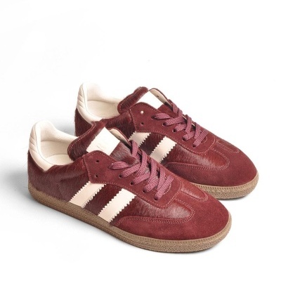 Ténis castanho-avermelhados com riscas brancas e sola castanha.