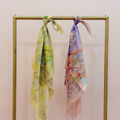 Duas echarpes florais penduradas em cabide dourado