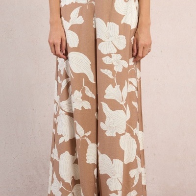 Calças largas castanhas com padrão de flores brancas grandes