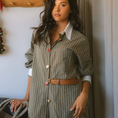 Camisa às riscas castanha com botões coloridos e cinto castanho em modelo feminino