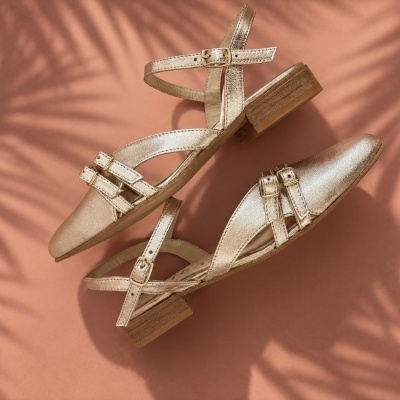 Sapatos dourados de senhora com salto baixo e fivelas