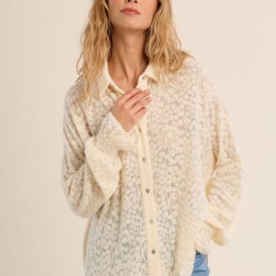 Blusa feminina bege clara com padrão felpudo e botões, combinada com jeans azul claro
