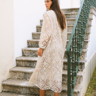 Vestido longo de renda bege com padrão ondulado e mangas compridas