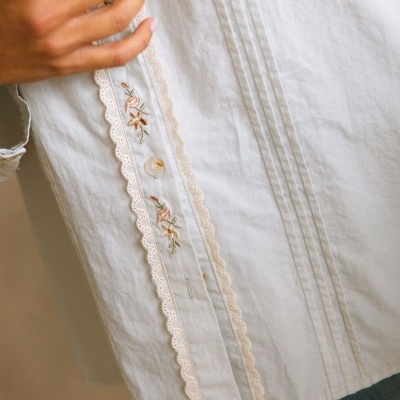 Camisa branca com bordado floral e detalhes rendados