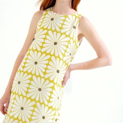 Vestido amarelo com grandes flores brancas usado por mulher ruiva