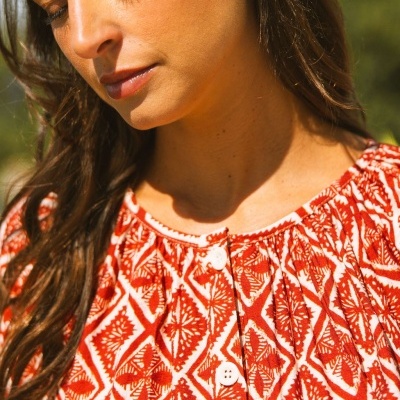 Blusa com padrão geométrico vermelho e branco com botões