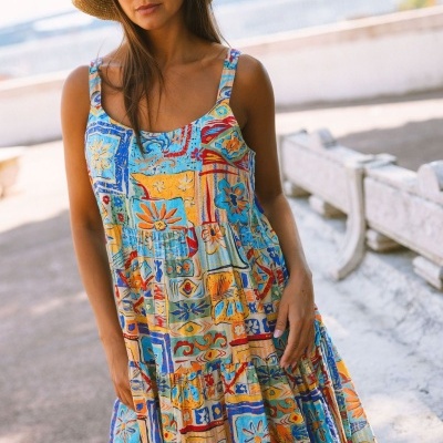 Vestido comprido de padrões coloridos com alças finas vestido por mulher com chapéu de palha ao ar livre