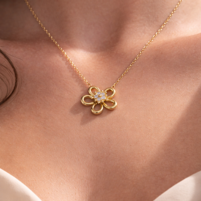 Colar dourado com pendente em forma de flor com pedras brilhantes no centro