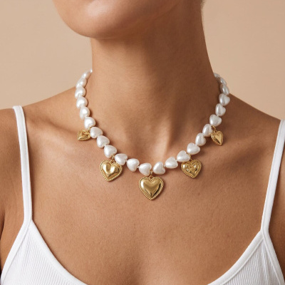 Colar com contas e pendentes de corações em pérolas e dourado.