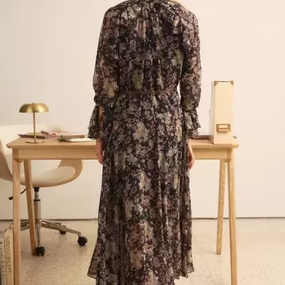 Vestido comprido floral com cinto fino num ambiente de escritório