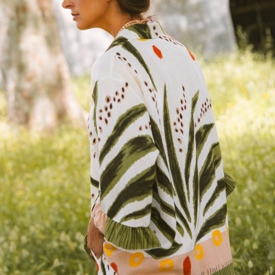 Kimono feminino estampado com folhas verdes e detalhes coloridos, usado ao ar livre