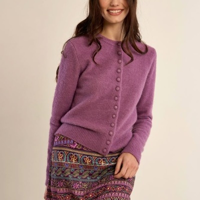 Camisola roxa de malha com botões e saia com padrão floral colorido.