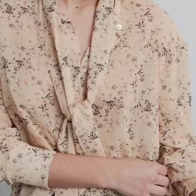 Blusa feminina cor de pêssego com padrão floral e laço ao peito