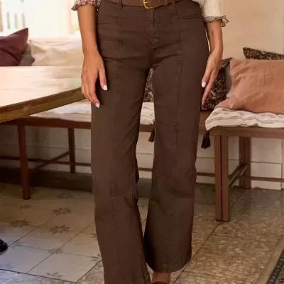 Calças femininas marrons com corte reto e sapatos castanhos em ambiente interior