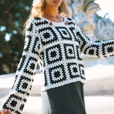 Camisola de malha crochetada preta e branca com padrão de quadrados usada ao ar livre