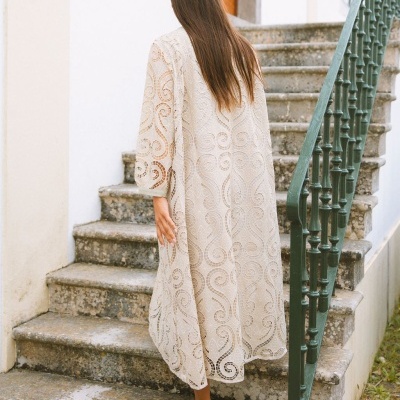 Vestido de renda creme com padrão arabesco em escada exterior