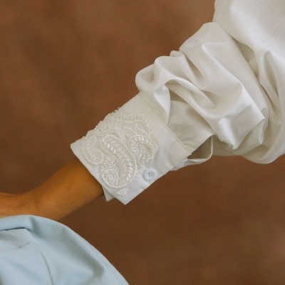 Punho de camisa branca bordada e manga volumosa