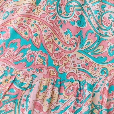 Tecido com padrão floral e arabescos em cores pastel e detalhe franzido