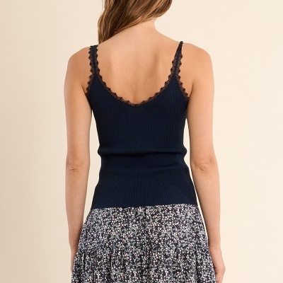 Mulher vista de costas com top azul escuro de malha e saia floral