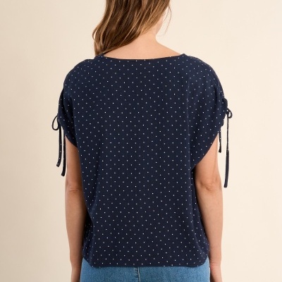 Blusa azul escuro com pontos brancos e mangas com cordões, vista de costas