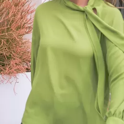 Blusa verde clara com gola alta e punhos largos