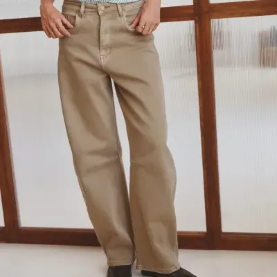 Pessoa vestindo calças castanhas, camisa às riscas e sapatos pretos
