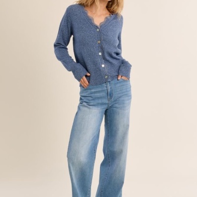Mulher com camisola de malha azul e calças de ganga largas