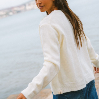 Camisola branca de malha fina usada por mulher junto ao mar
