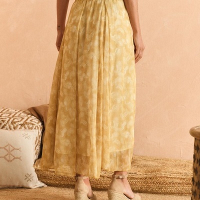 Saia amarela com padrão floral e sapatos de cunha juta