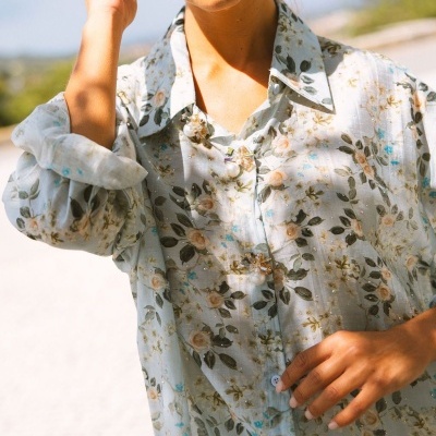Camisa leve feminina com padrão floral e botões decorativos ao ar livre