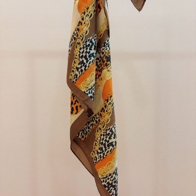 Lenço colorido pendurado com padrão animal print e correntes douradas