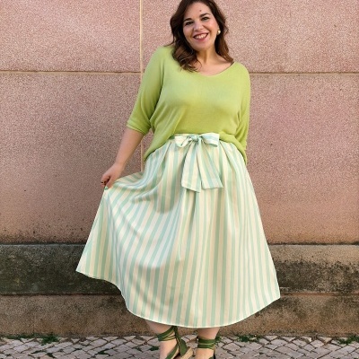 Mulher vestindo blusa verde-limão, saia listrada branco e verde e sandálias espadrille verdes