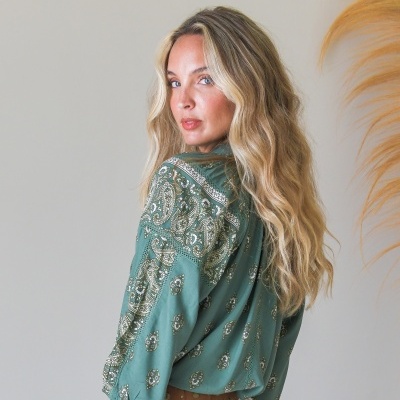 Mulher de costas roupa verde com padrão paisley e saia branca rendada