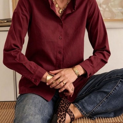 Camisa bordô de manga comprida com gola folhada e calças de ganga azuis com sapatos animal print