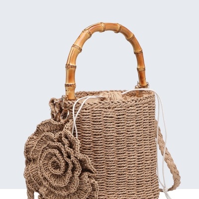 Mala de mão de palha com alça de bambu e flor de croché