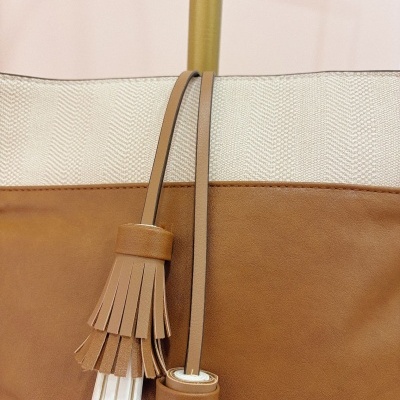 Mala tote bege e castanha com pompons decorativos