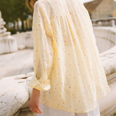 Blusa amarela clara com padrão de corações pequenos em diferentes cores