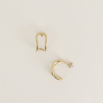 Brincos dourados em metal sobre fundo branco