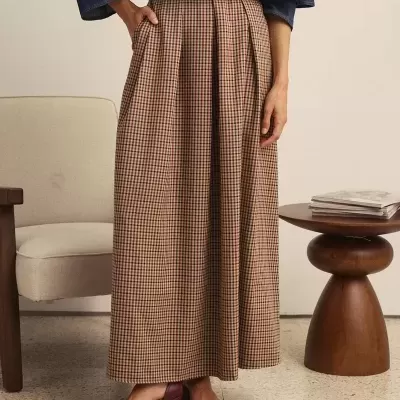 Saia longa xadrez castanha e bege com sapatos vinho e parte superior azul