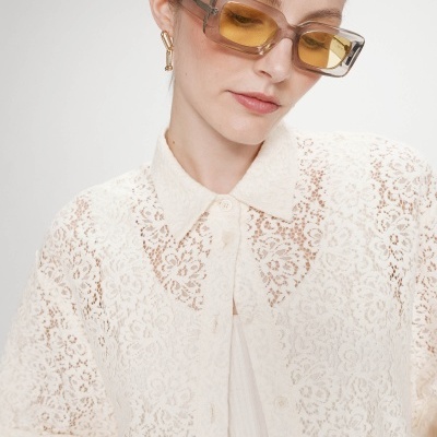 Óculos de sol retangulares com lentes amarelas e blusa rendada creme