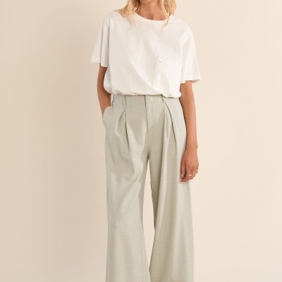 Mulher com t-shirt branca e calças cinza largo