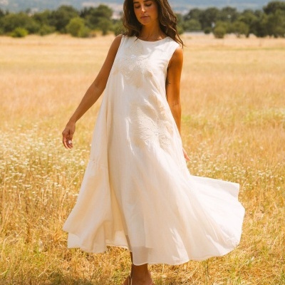 Vestido longo branco com bordado floral e tecido leve usado ao ar livre