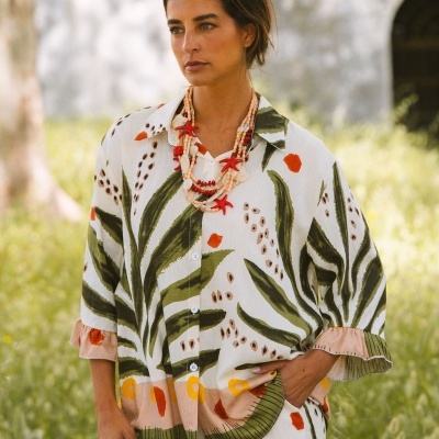 Conjunto de camisa e calças florais com colar de conchas, modelo ao ar livre