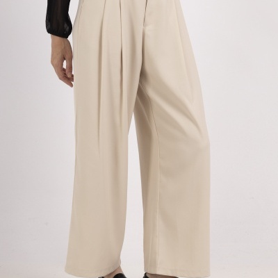 Calças largas bege com camisa preta e sapatos pretos