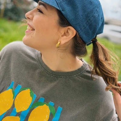 Pessoa com boné azul e t-shirt com estampa de limões