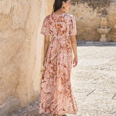 Vestido comprido feminino com padrão paisley rosa e castanho visto pelas costas