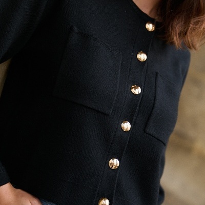 Cardigan preto de malha com botões dourados e bolsos quadrados no peito