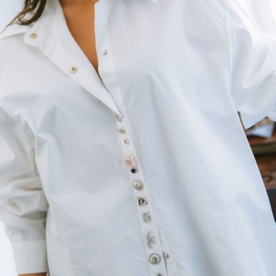 Camisa branca com botões decorativos variados e logótipo maittè