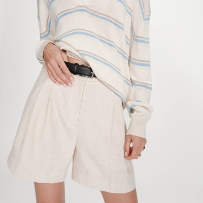 Casaco de malha bege com riscas azuis e castanhas e calções largos bege com cinto preto